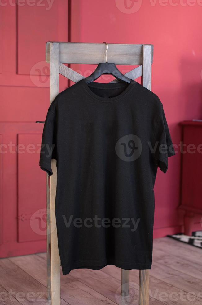 A set of mockups of a black hoodie with a hood and a pocket hanging on a hanger photo