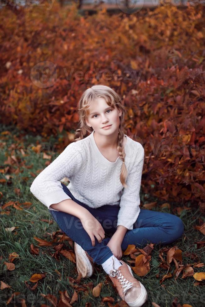 A happy girl stands in the autumn forest photo