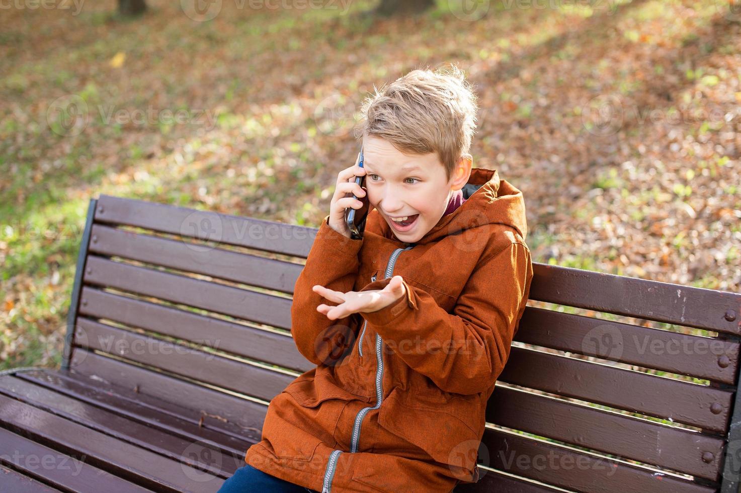 Emotional boy talking on the phone and laughing photo