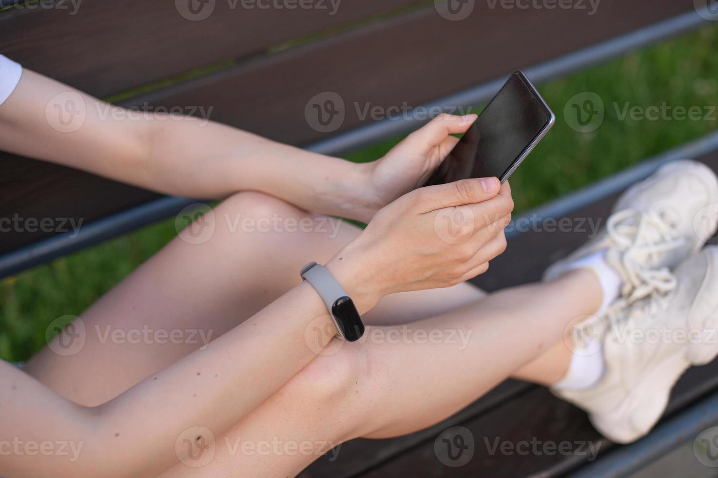 el niña es participación un blanco teléfono en su manos, un Deportes reloj en su mano foto