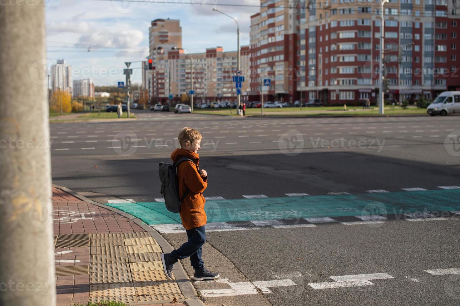 un estudiante cruces el la carretera a un peatonal cruce foto