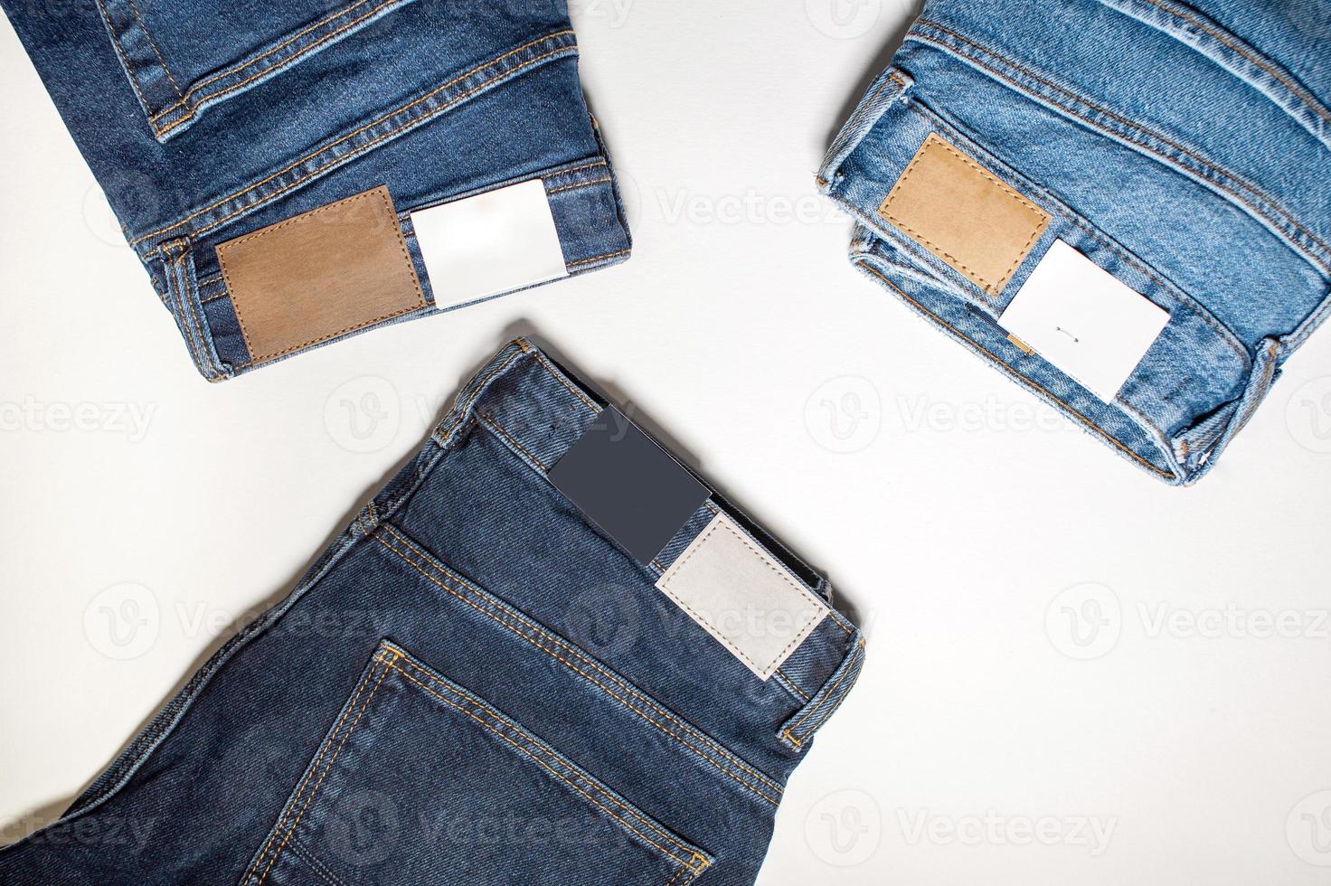 Three pairs of new denim trousers on a white background. photo