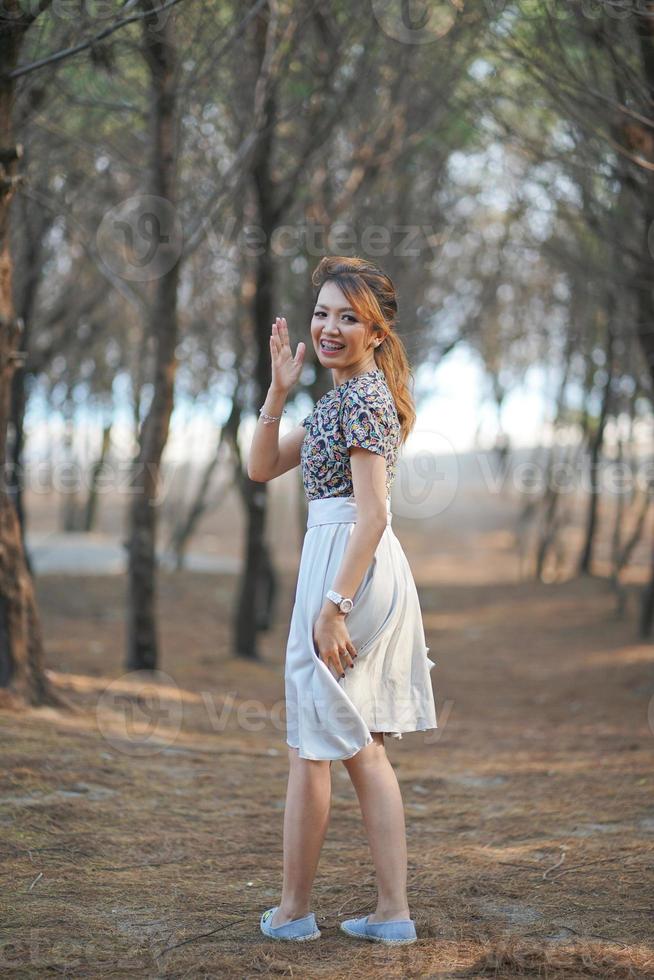 mujer sonriente y ondulación mano con seco ramas antecedentes foto