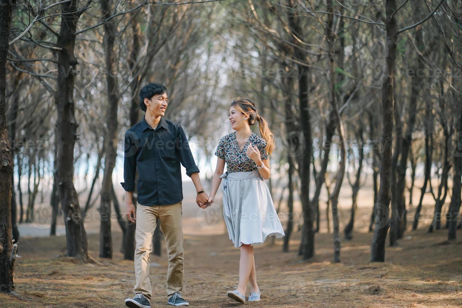 Smiling Couple Holding Hands among Dry Branches photo