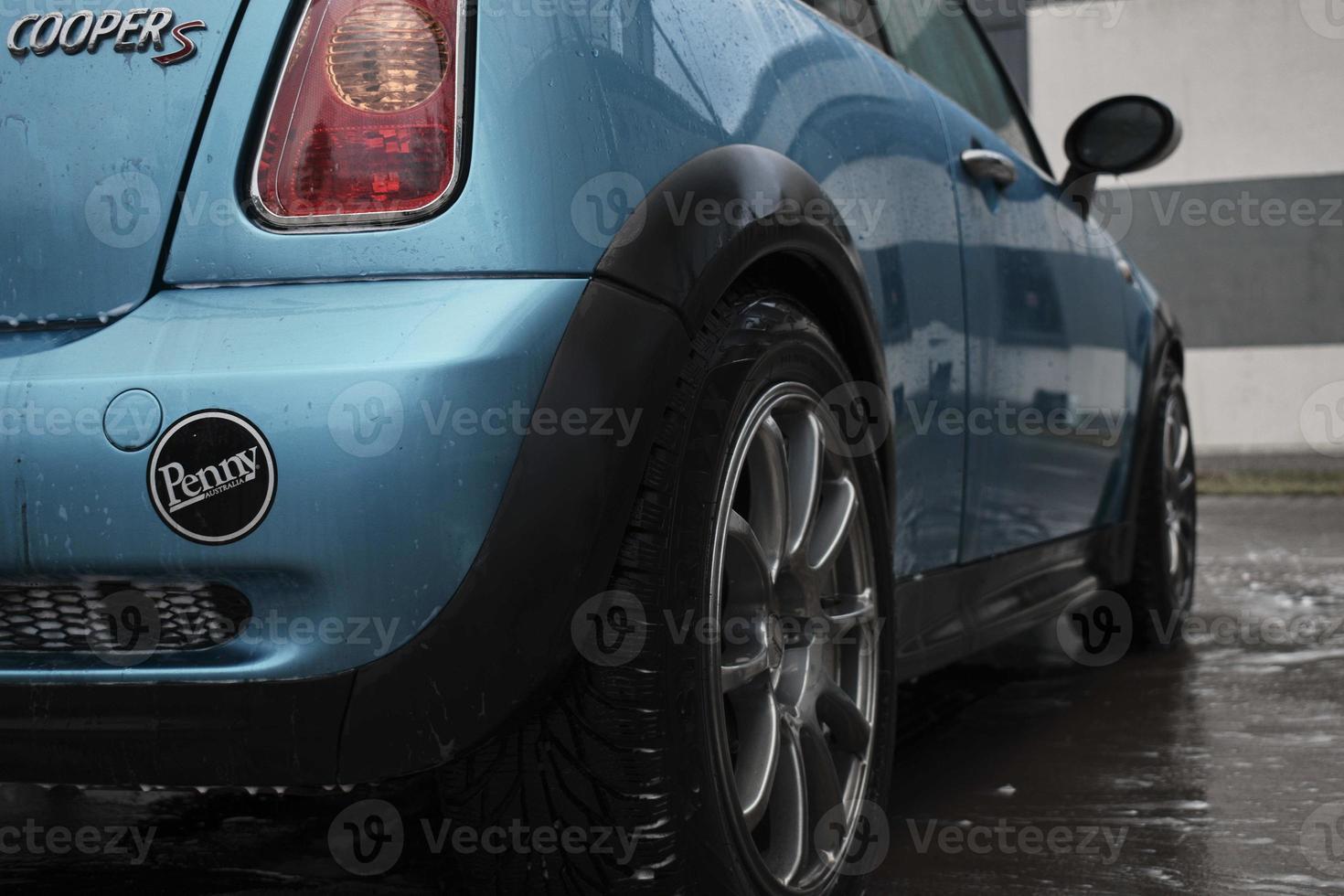Hand wash with soap, pink foam on the body. Car washing with high pressure water. Wash Mini Cooper. photo