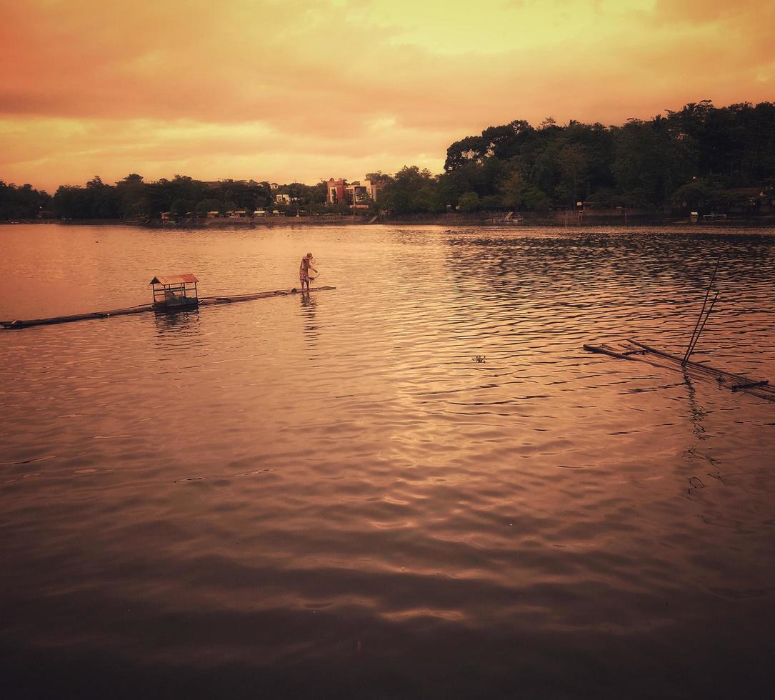 The view at dusk with fishermen in the middle of the lake. photo