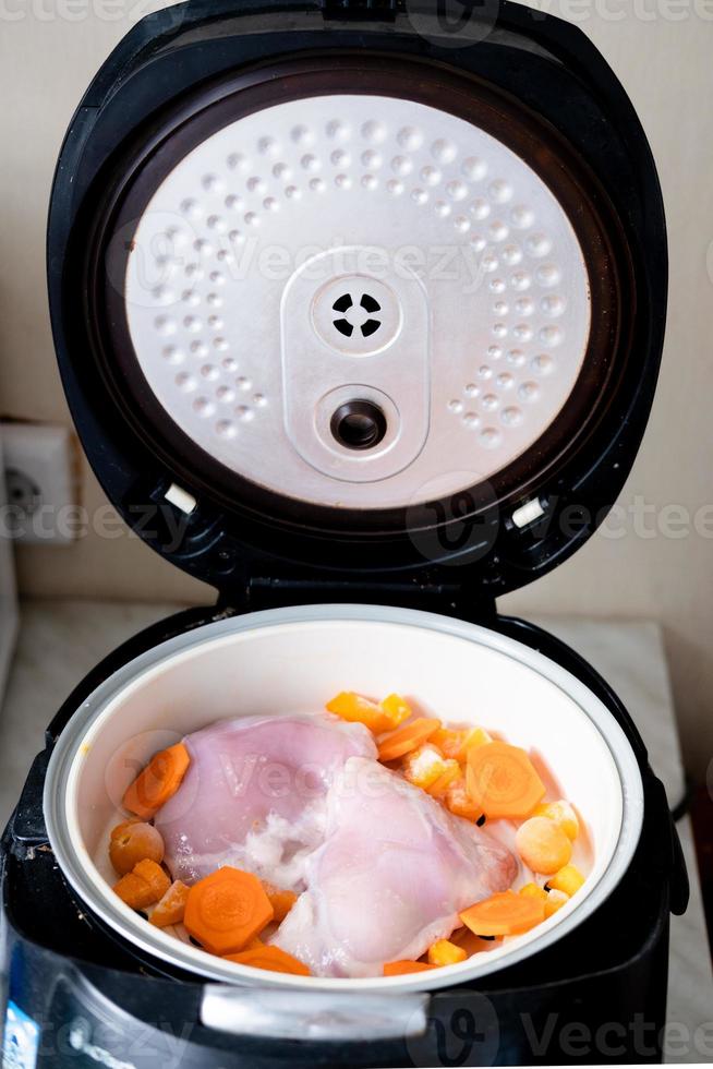 chicken meat and carrot pieces in a double boiler, top view. Steamed meat and vegetables photo