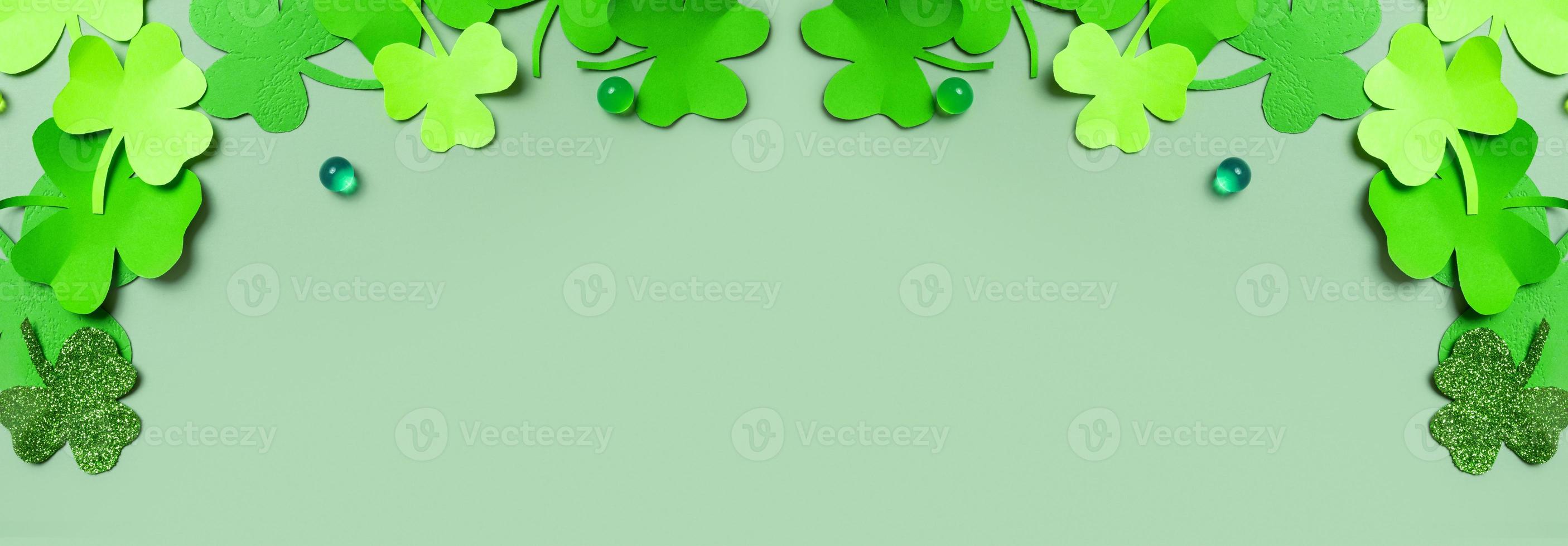 St. Patrick's Day banner. Paper clover leaves on colored background with copy space photo