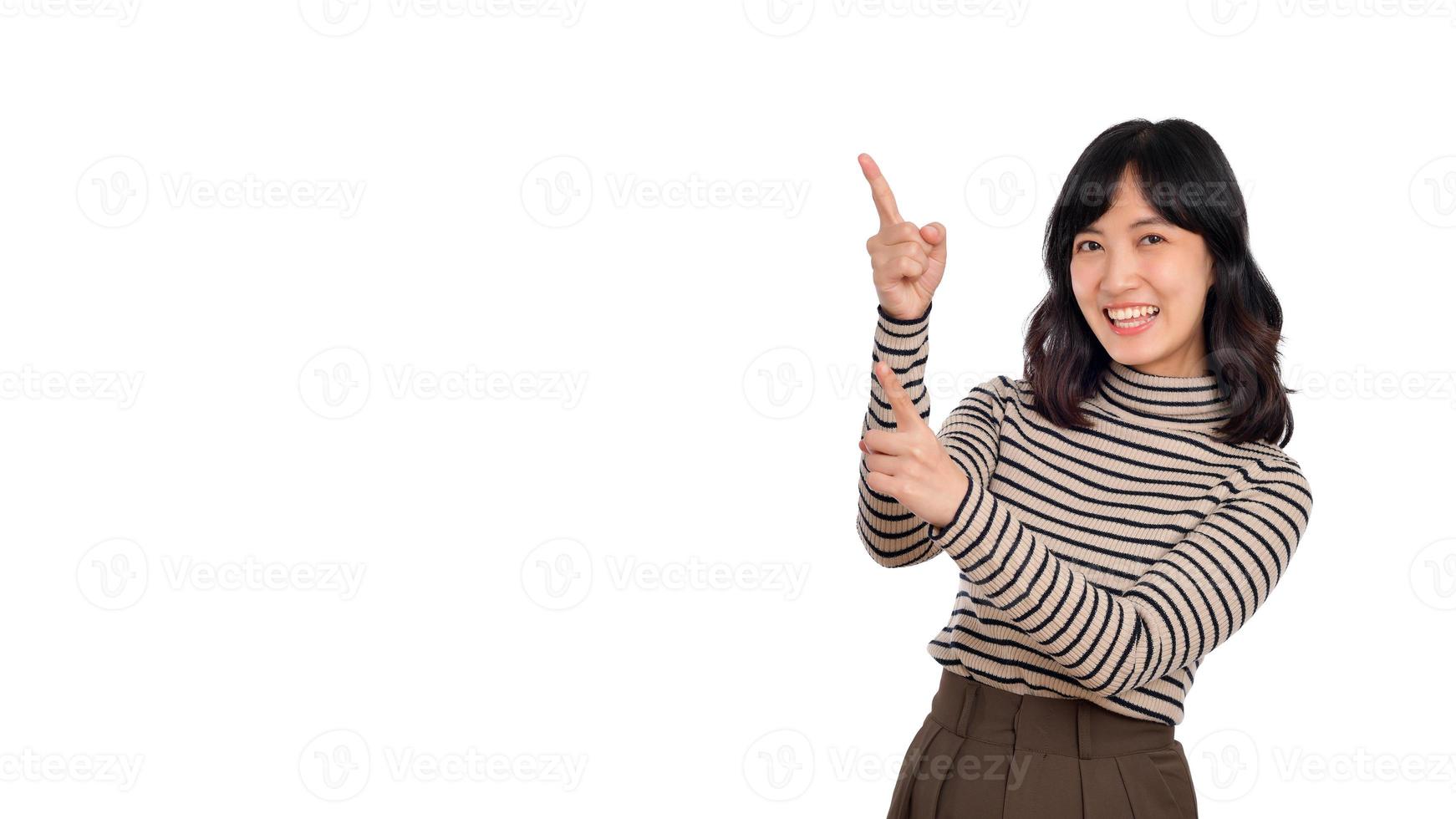 Beautiful young Asian woman on sweater cloth pointing up to copy space and looking at camera with smile face and happy isolated on white background photo