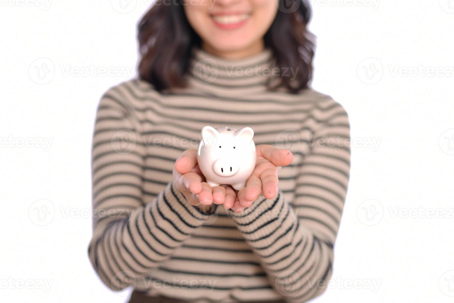 Portrait of young Asian woman casual uniform holding white piggy bank isolated on white background, Financial and bank saving money concept photo