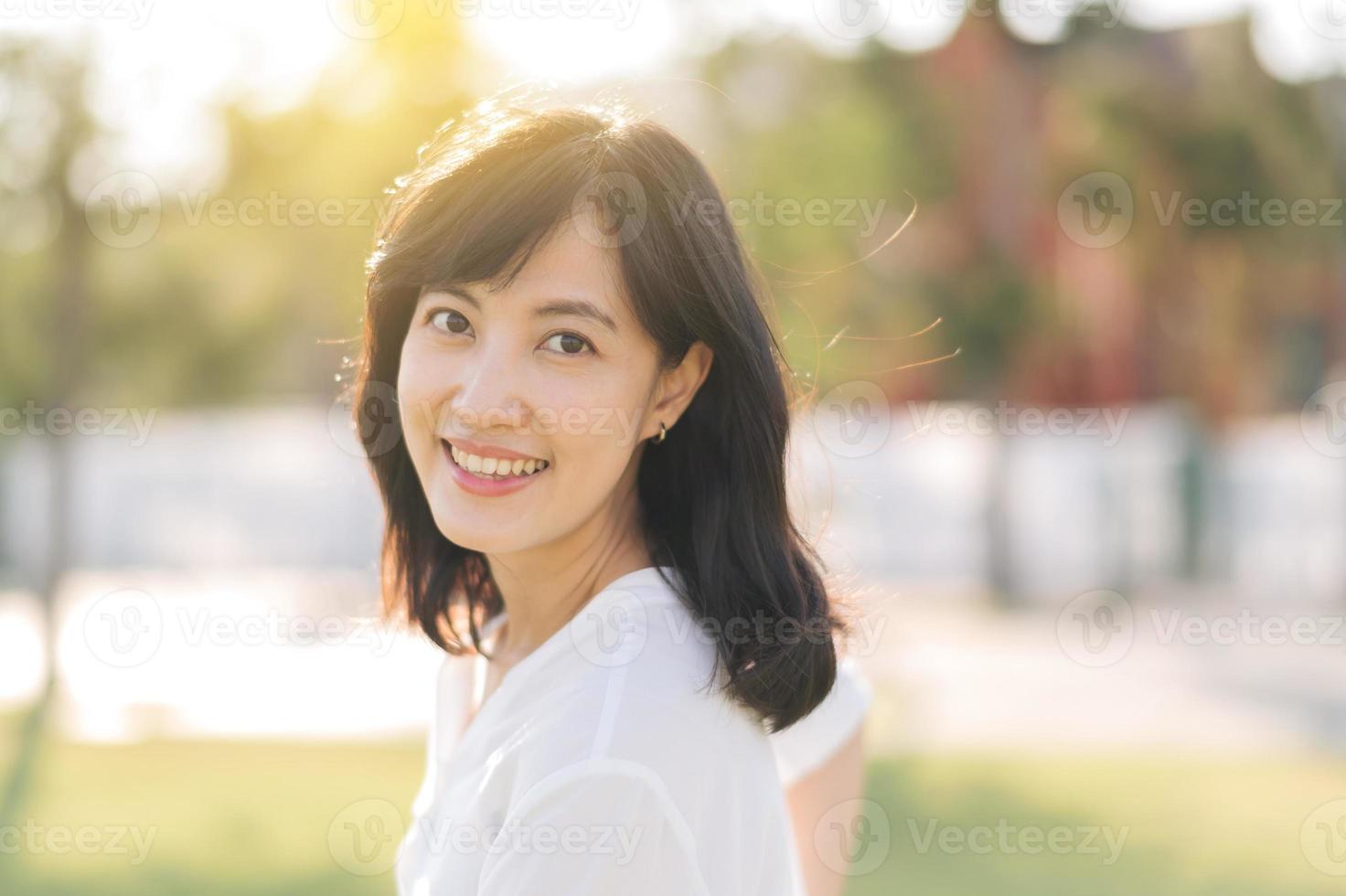 Portrait young beautiful asian woman with happy smile around outdoor park in sunny summer day photo