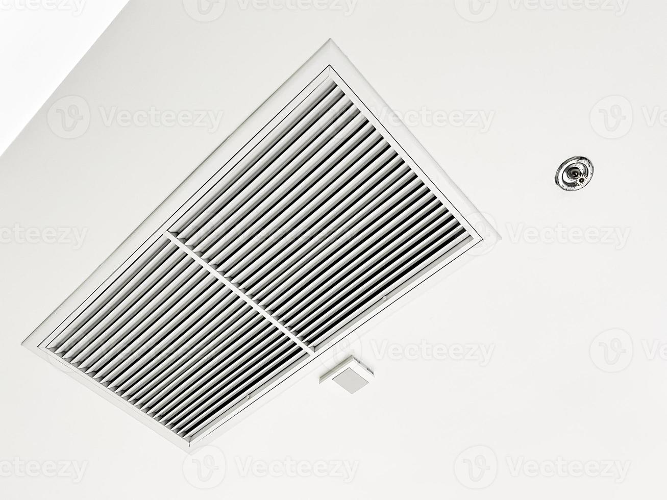 Ceiling mounted cassette type air conditioner and modern lamp light on white ceiling. duct air conditioner for home or office photo