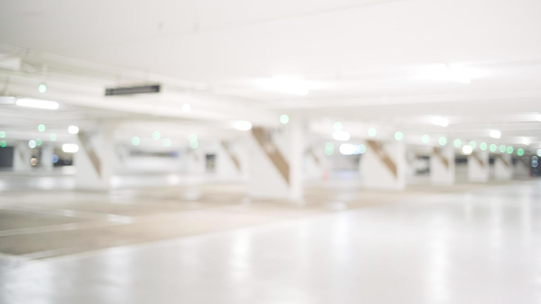 Blur image of empty car park in basement of garage shopping mall. Defocused interior background concept photo