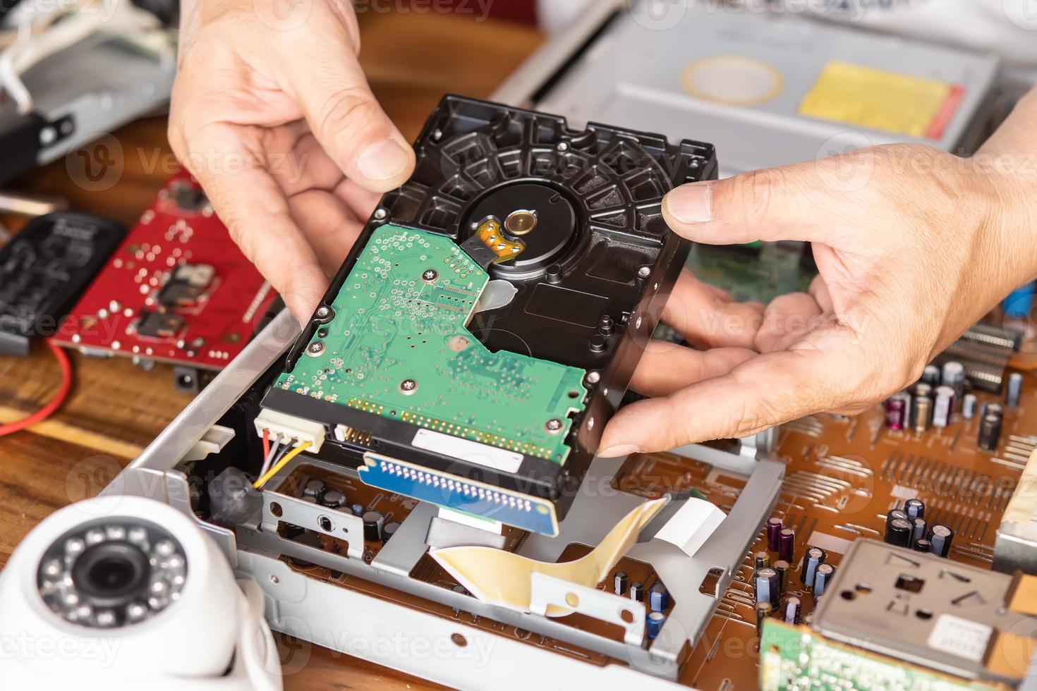 Technician remove a hard disk drive from the CCTV DVR recorder case, to install a new hard drive and upgrading to a Solid State for backup CCTV camera , electrical work and cctv concept photo