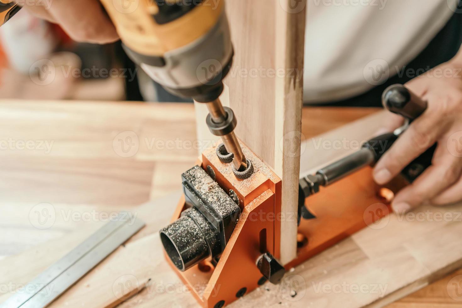 Carpenter use drill bit Pocket hole joinery, or pocket screw joinery, involves drilling a hole at an angle ,make strong joints on wooden plate. D.I.Y and woodworking concept.selective focus. photo