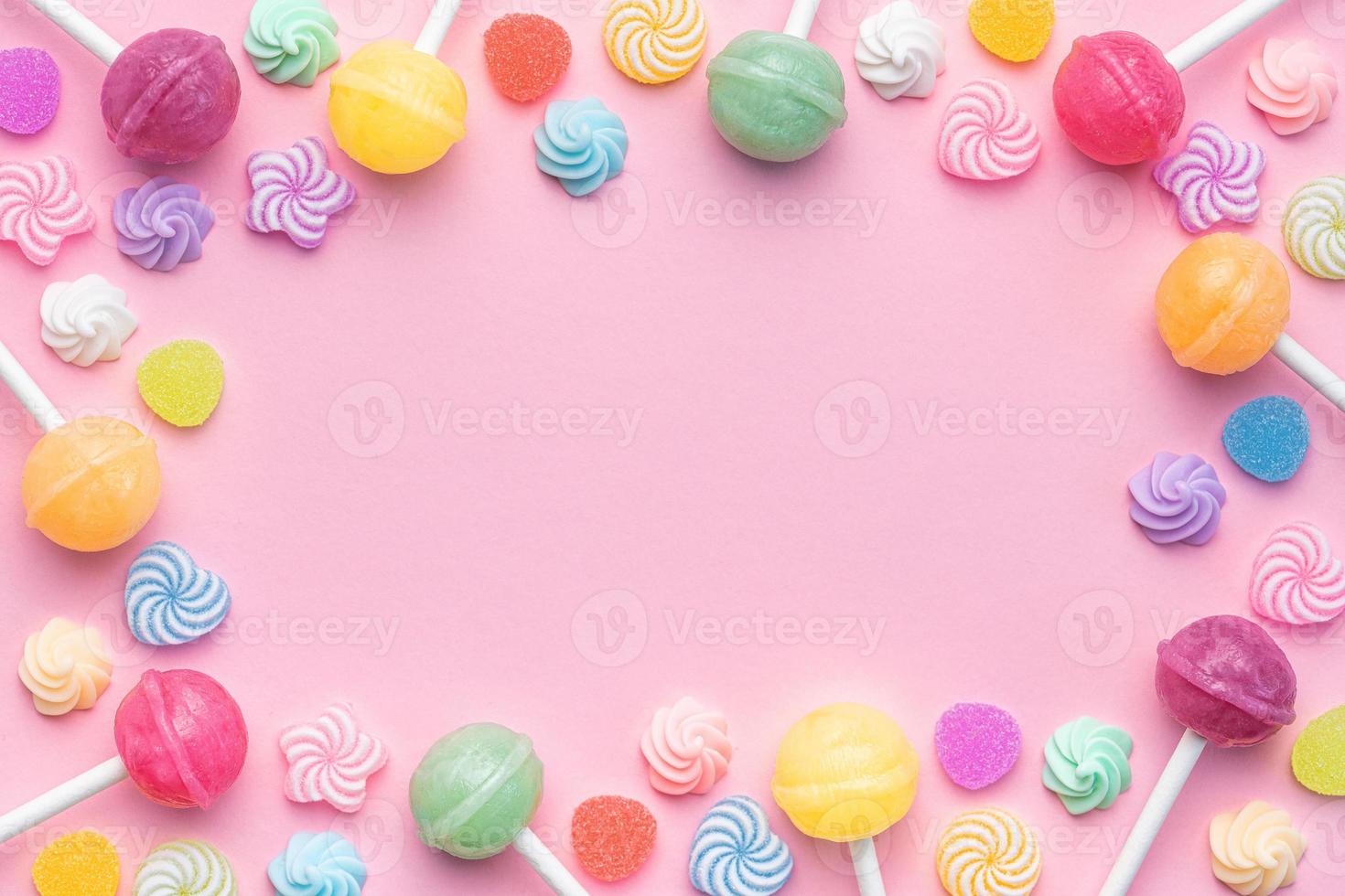 Sweet lollipops and candies on pink background photo