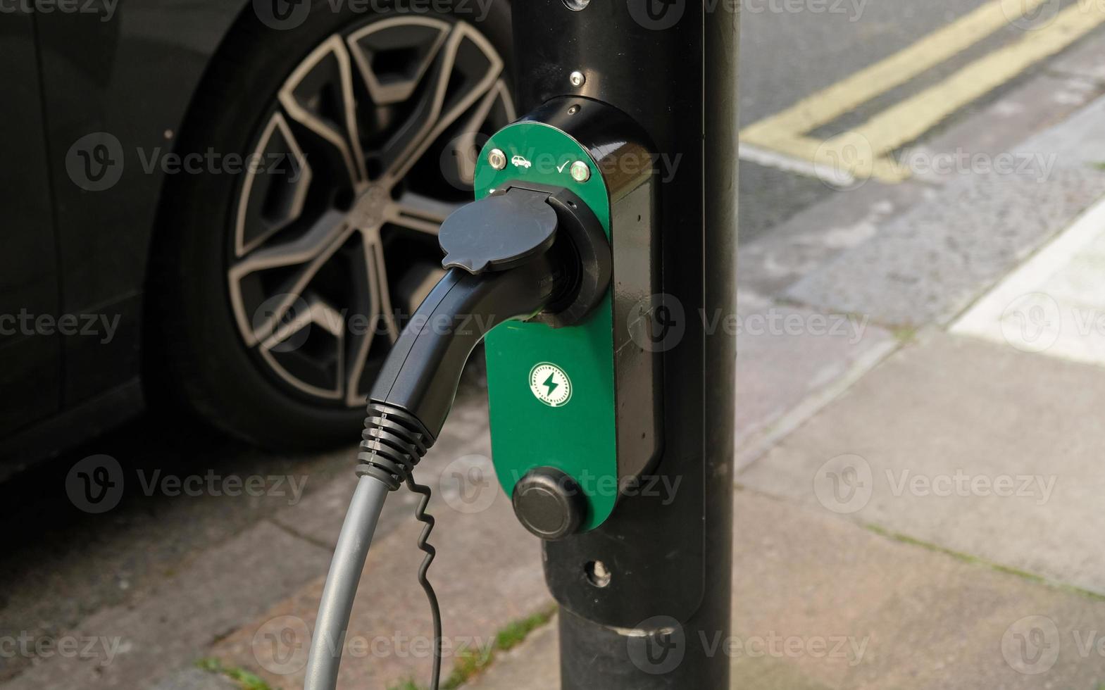 Electric vehicle charging at a public charging station in a city setting. New energy vehicles, eco-friendly alternative energy for cars. Electric cars are becoming more common and gaining popularity. photo