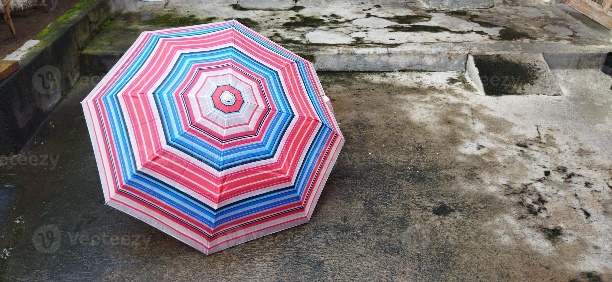 colorful patterned umbrellas in the yard after rain. rainbow umbrella. natural background. colorful umbrella, symbol of rainy weather season. copy space. banner photo