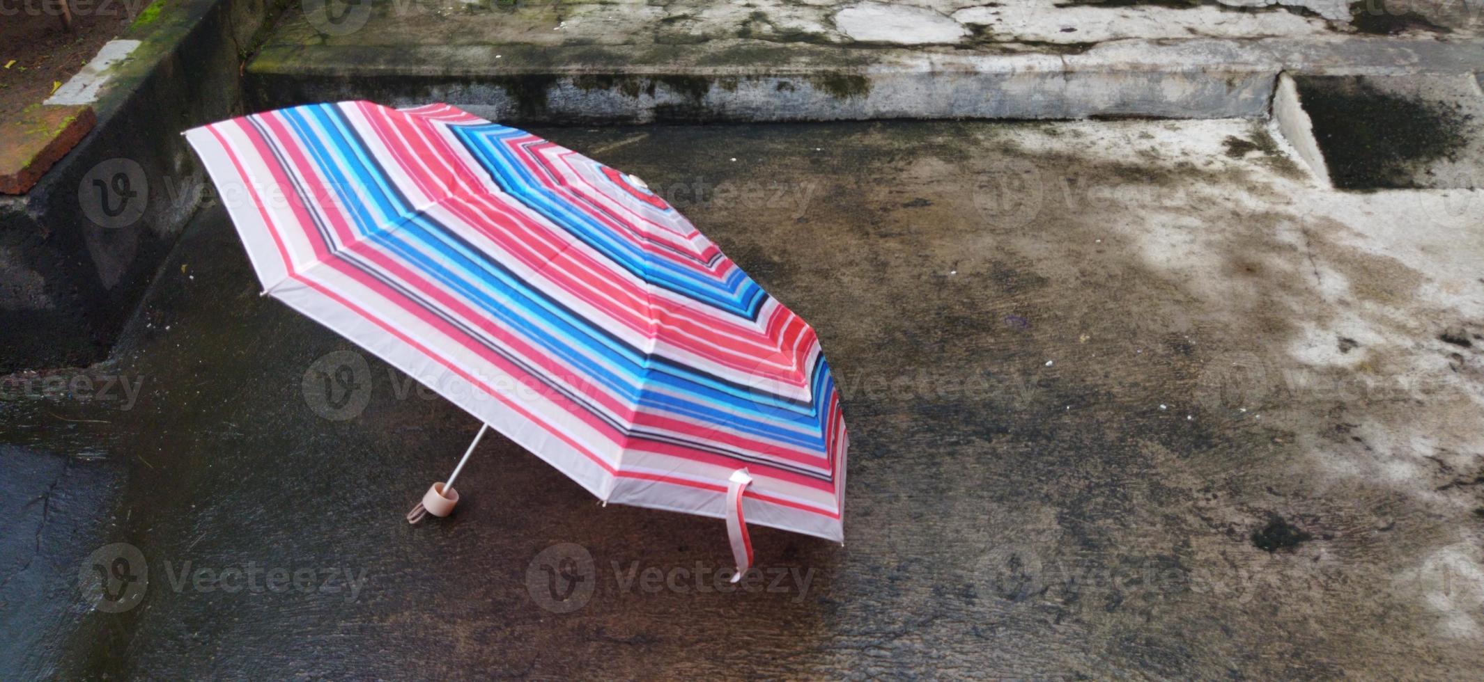 colorful patterned umbrellas in the yard after rain. rainbow umbrella. natural background. colorful umbrella, symbol of rainy weather season. copy space. banner photo