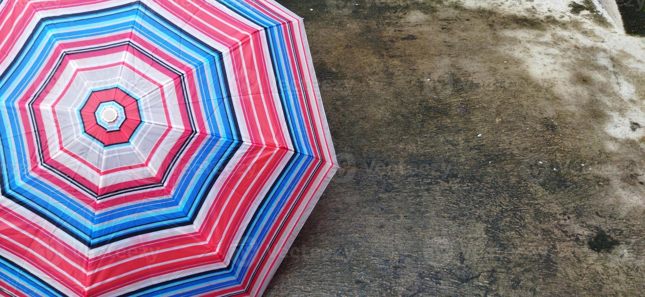 colorful patterned umbrellas in the yard after rain. rainbow umbrella. natural background. colorful umbrella, symbol of rainy weather season. copy space. banner photo