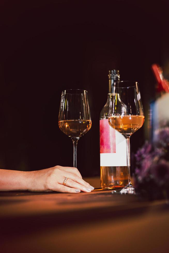 mujer mano participación vino vaso en cena mesa en el restaurante. foto