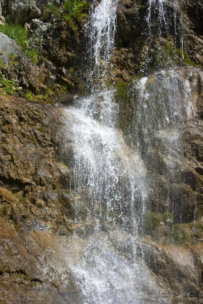 Beautiful waterfall in the mountains. Water flows down from the mountains. photo