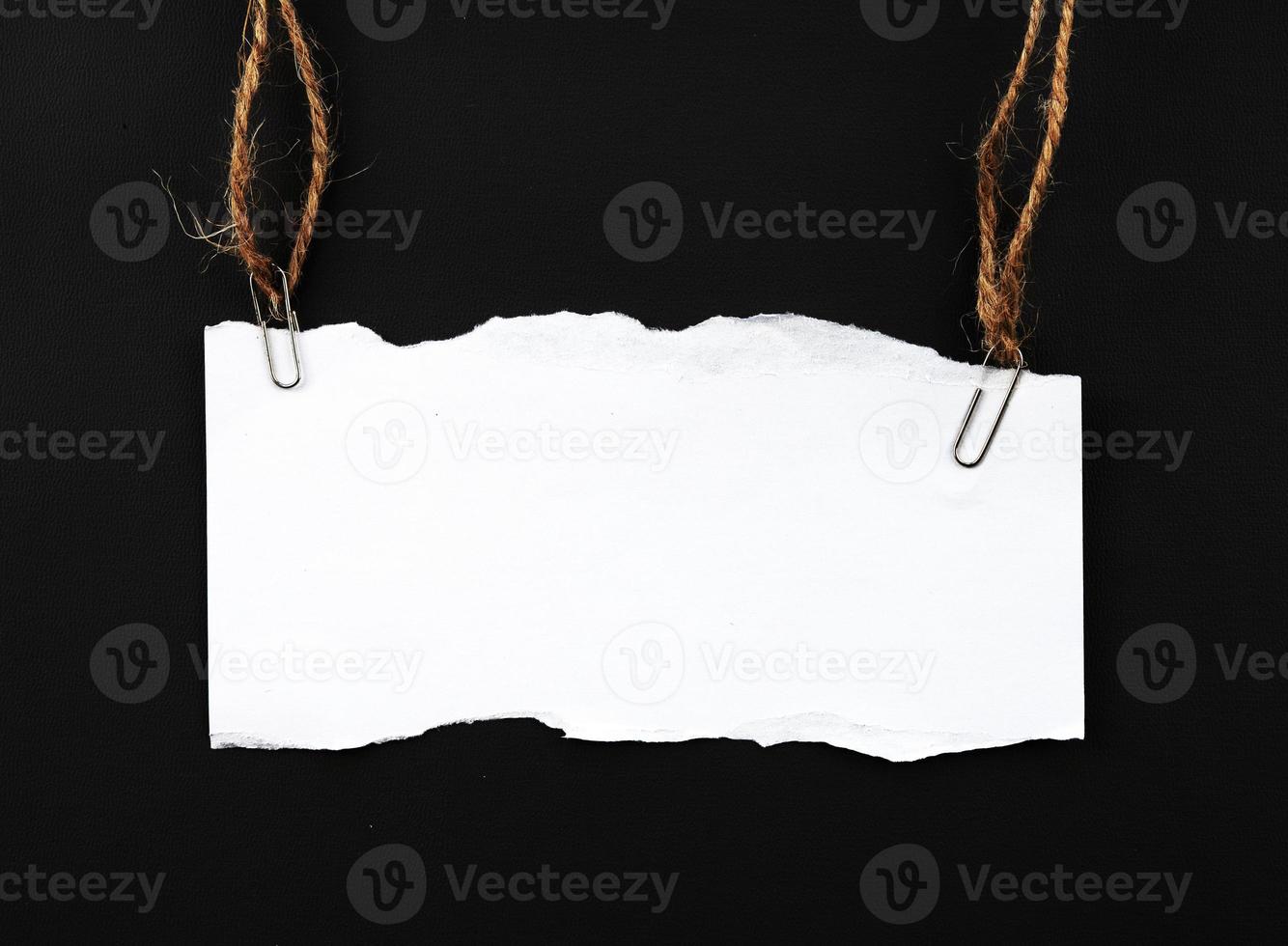 blank ripped paper hanging on rope photo