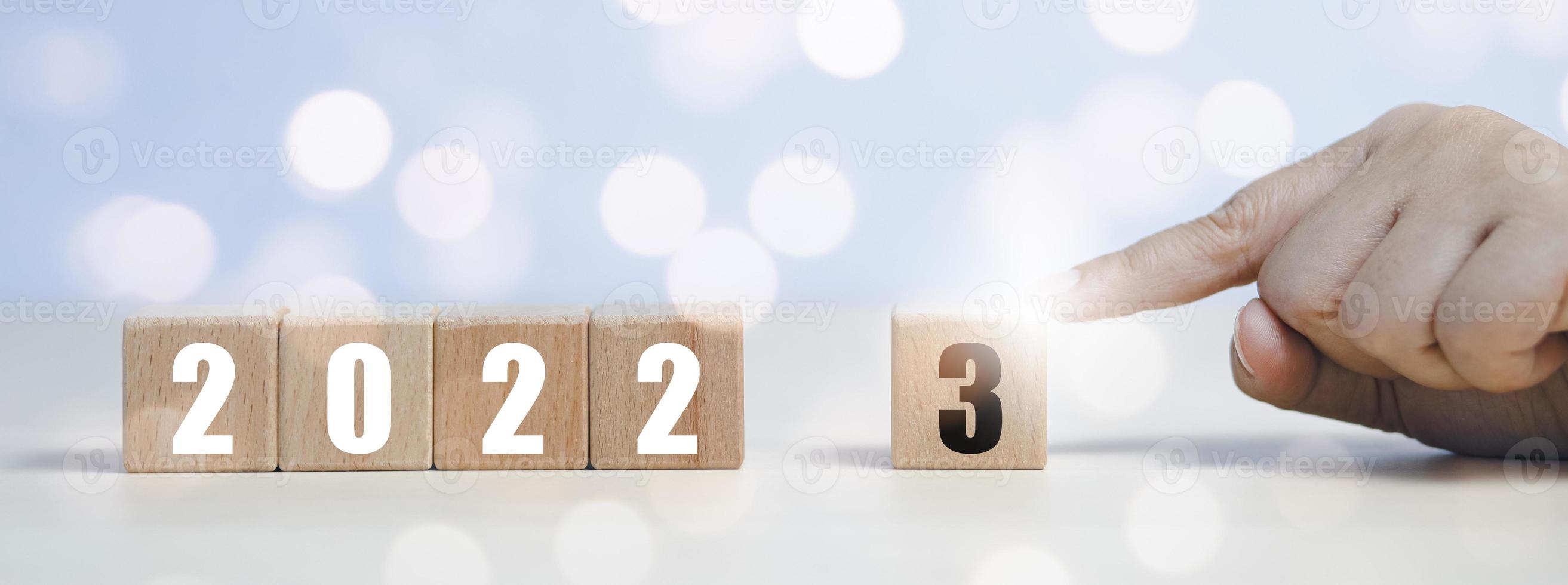 Concept 2022-2023, Hand touch square wood and icon on white background, Money spending planning, plant growing up on coins and investment budget, Save money for prepare in the future, new year photo