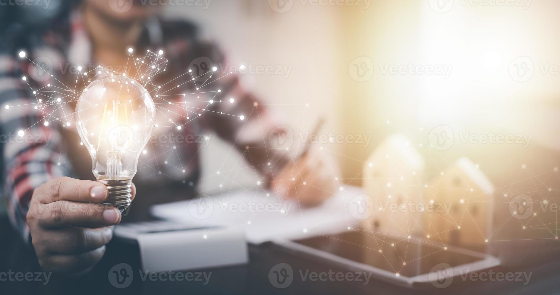 Businesswoman hand holding light bulb with icons and working on the desk, Creativity and innovation are keys to success.Concept of new idea and innovation with energy and power , working at home, photo