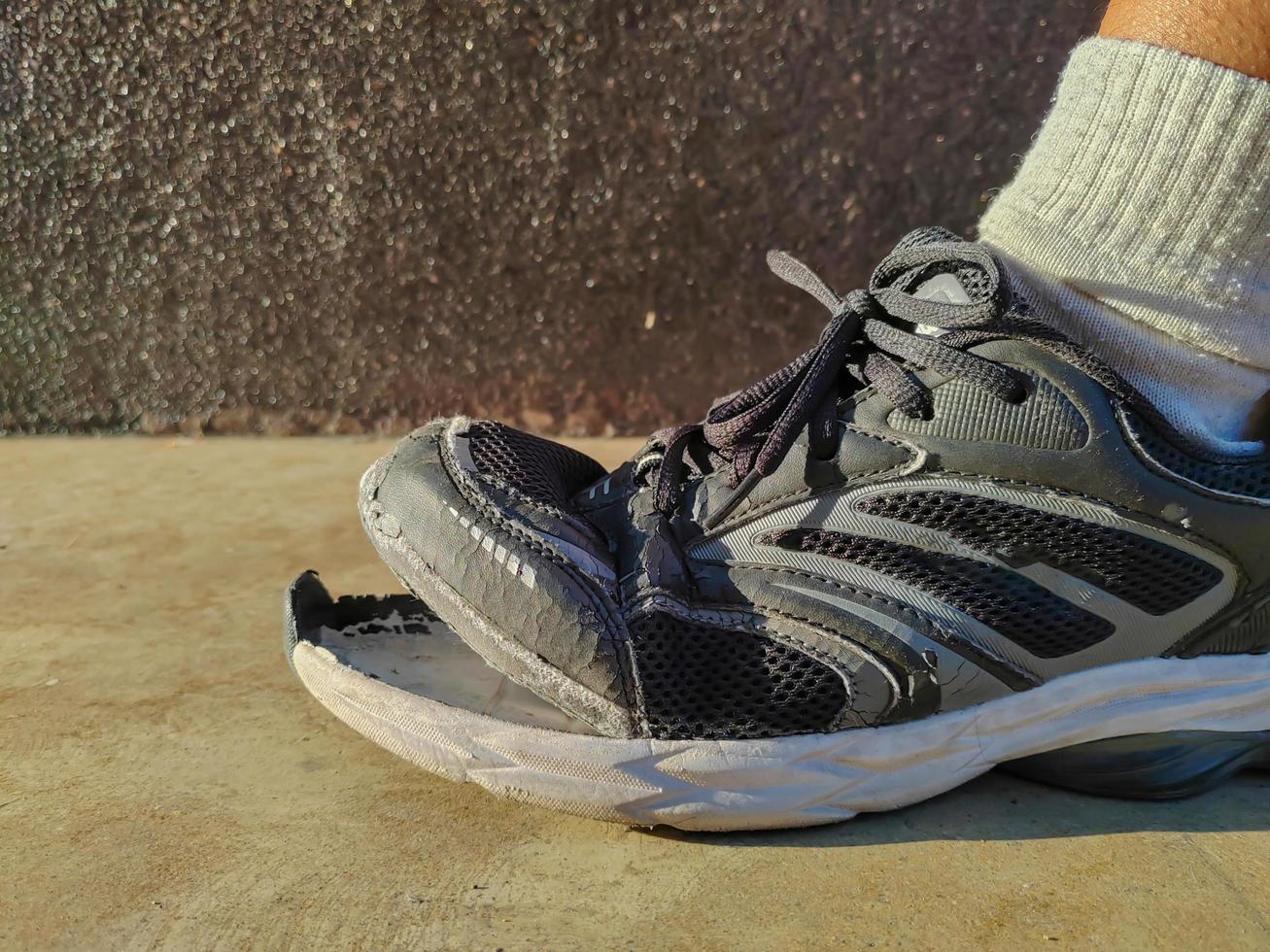 side view of torn shoes, shoes in need of repair photo