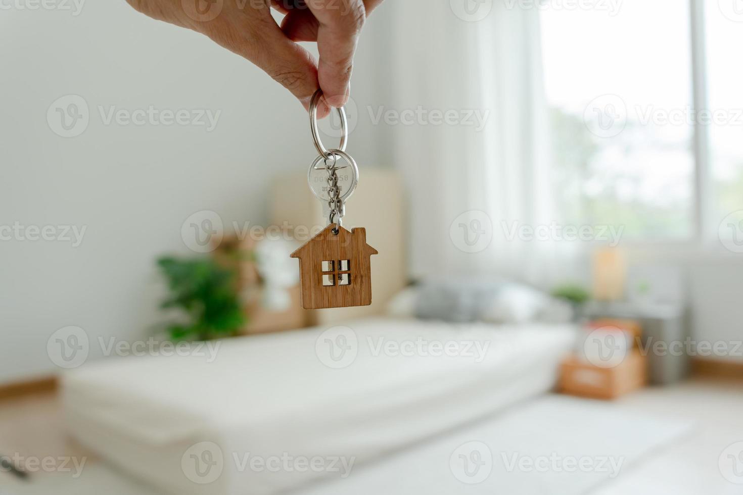 Moving house, relocation. The key was inserted into the door of the new house, inside the room was a cardboard box containing personal belongings and furniture. move in the apartment or condominium photo