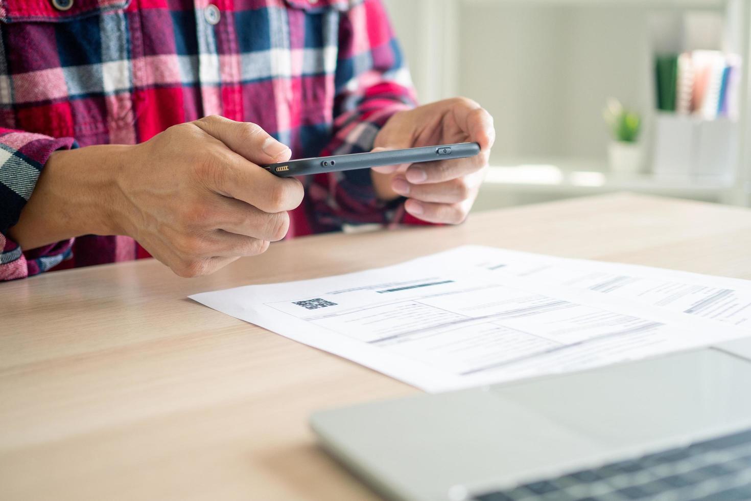 negocio hombre utilizando un móvil teléfono a pagar cuentas utilizando móvil teléfono aplicaciones en línea pago y compras conceptos. foto