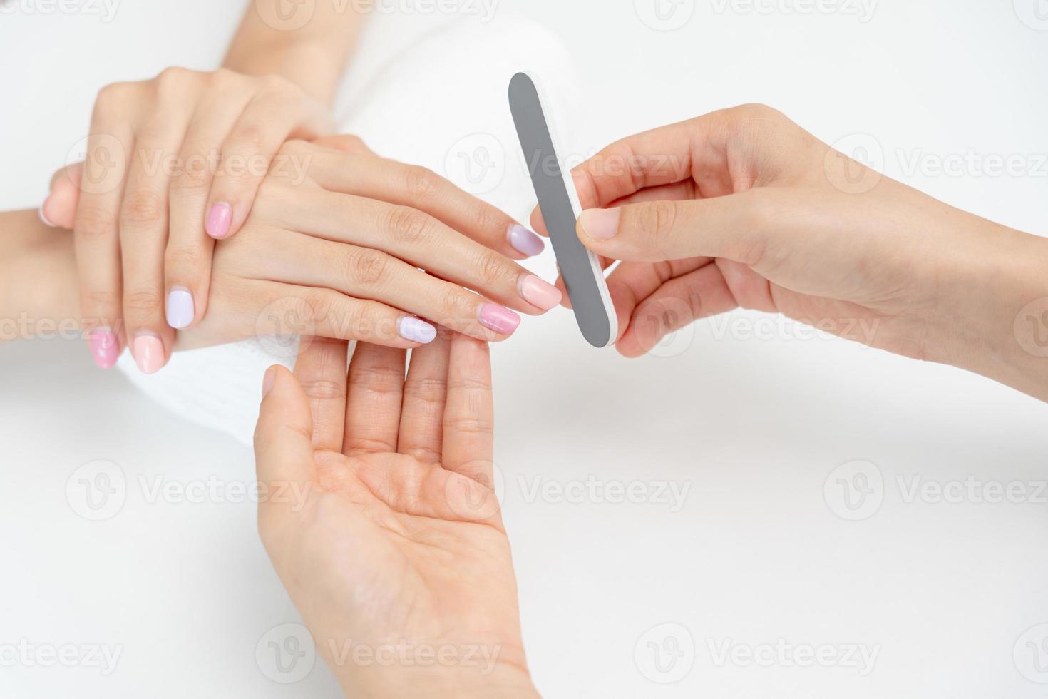 Woman receive care service by professional Beautician Manicure at spa centre. Nail beauty salon use nail file for Glazing treatment. manicurist make nail customer to beautiful. body care spa treatment photo