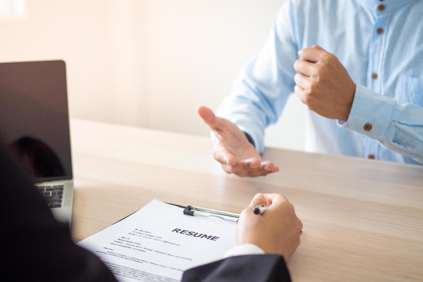 The applicant is introducing himself and explain the methods and techniques of working together with others in front of the executives to consider employment in the company. Resume and job interview. photo