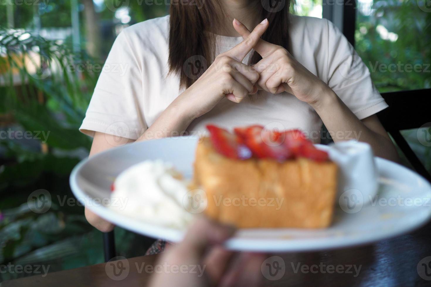 mujer negar a comer dulces para peso pérdida y bueno salud. foto