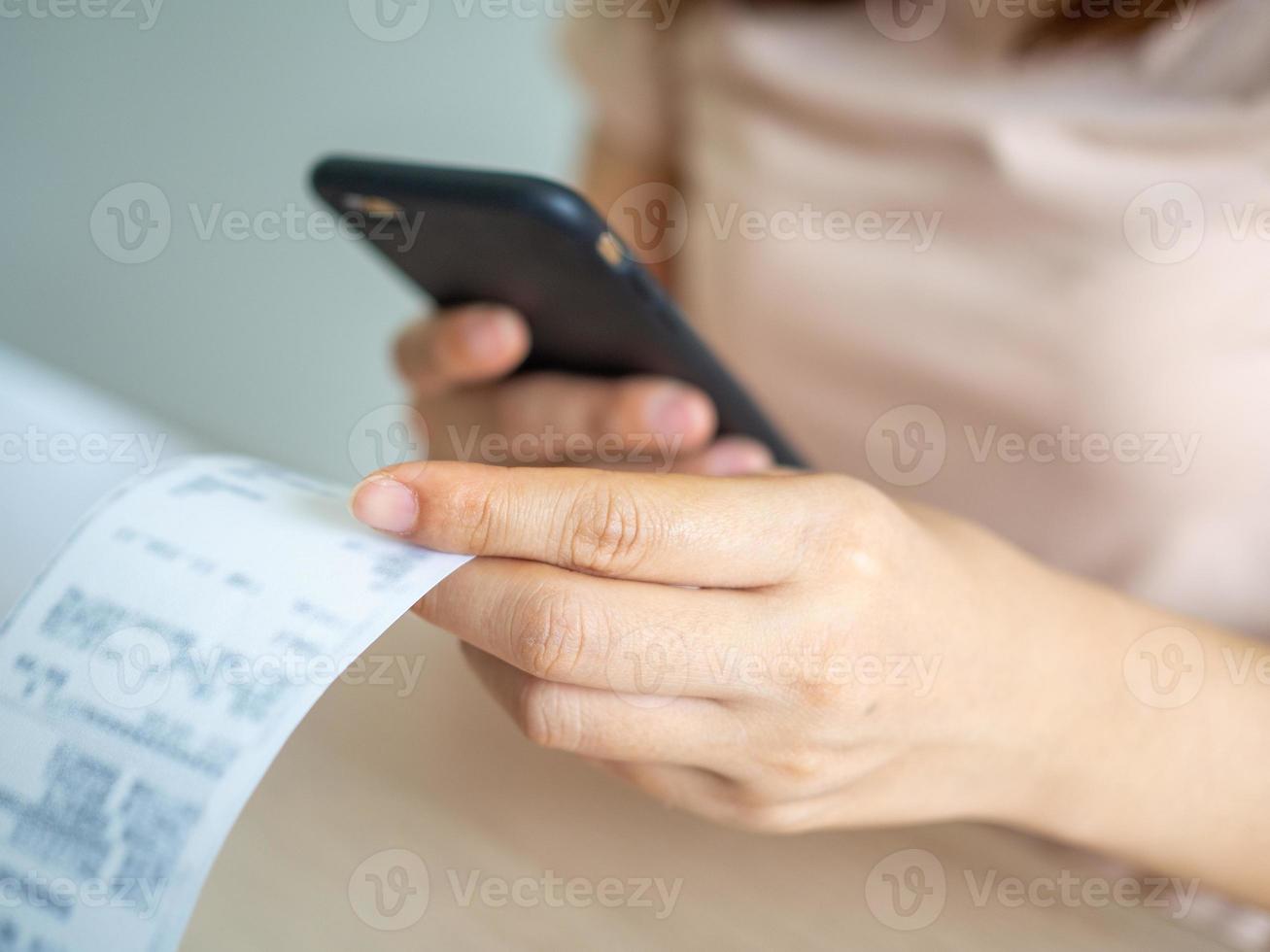 The hand uses the phone to scan the QR code to receive a discount from paying electricity bills at the office photo