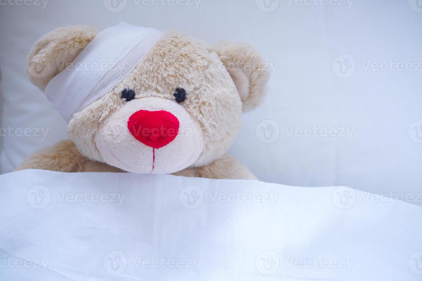 Creamy teddy bear injured in a wound after an accident photo