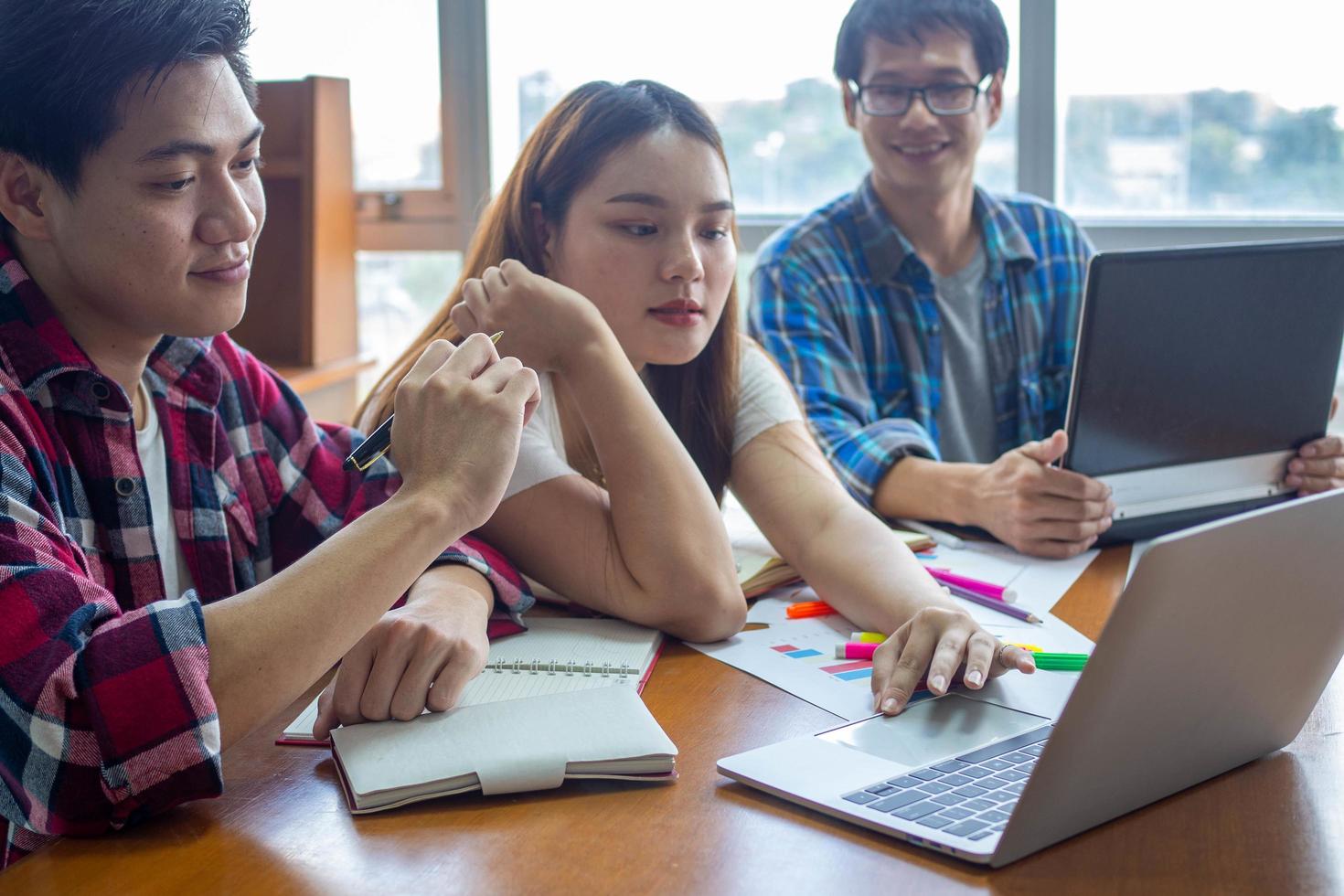 Asian university students read books and study together in the library. photo