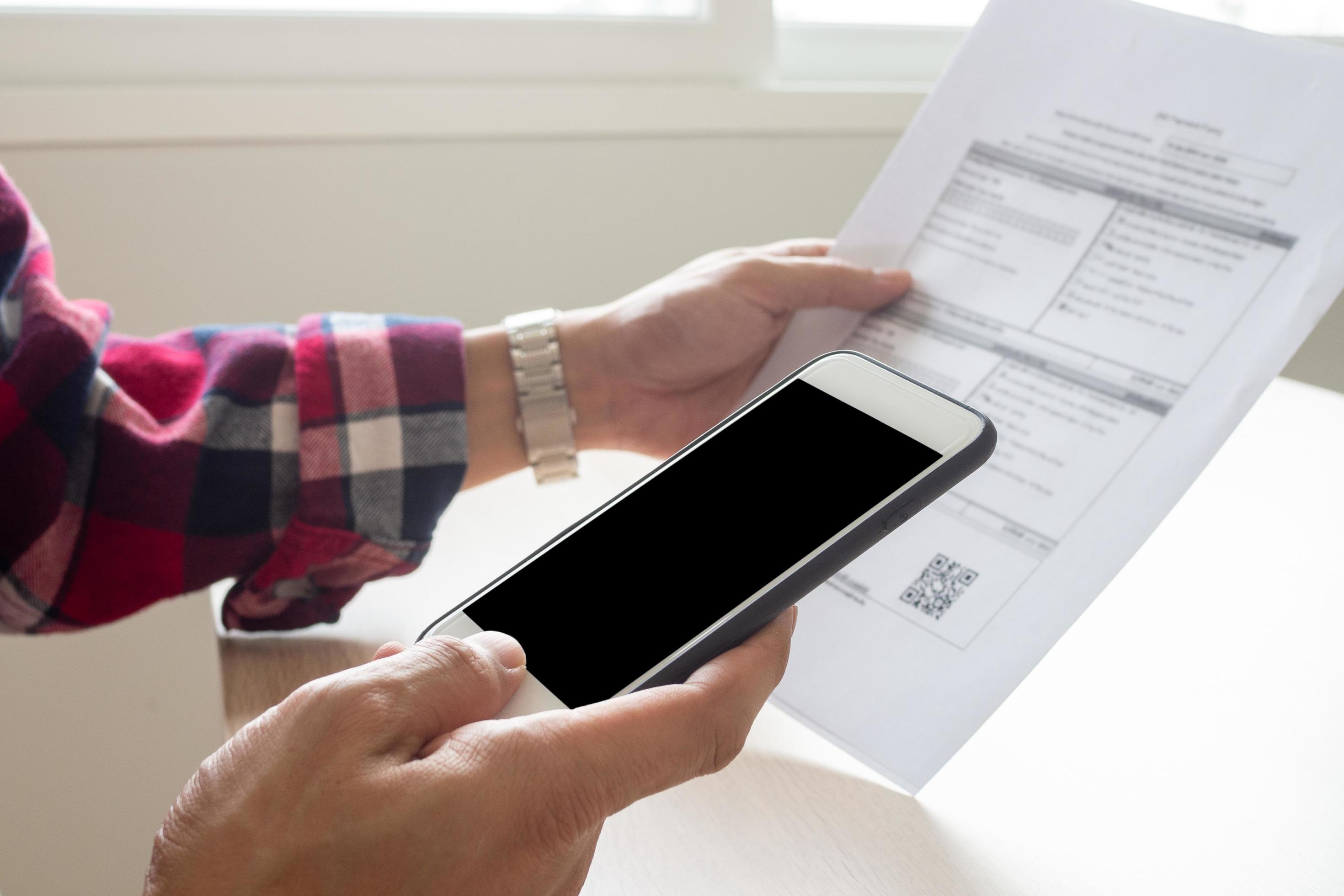 The hand uses the phone to scan the QR code to receive a discount from