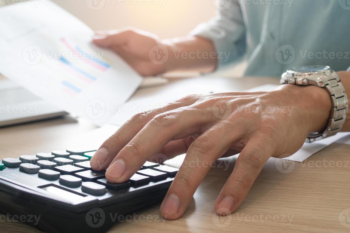 Businessmen sit and press the calculator to calculate and predict the company's power output according to the previous statistics held. photo