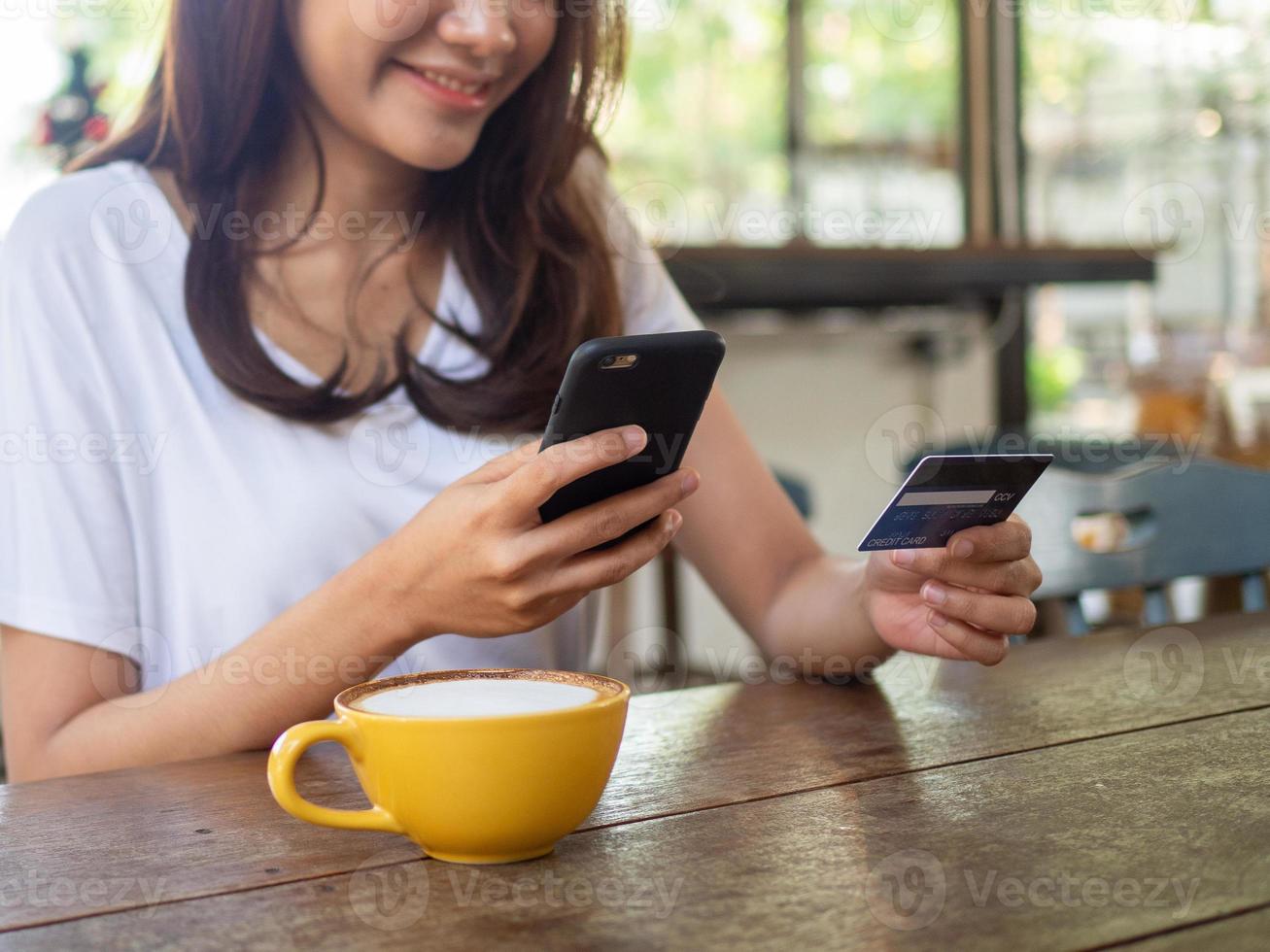 el muchachas son contento a orden productos en línea por conectando a el Internet vía teléfonos inteligentes y pago en línea por crédito tarjeta. foto