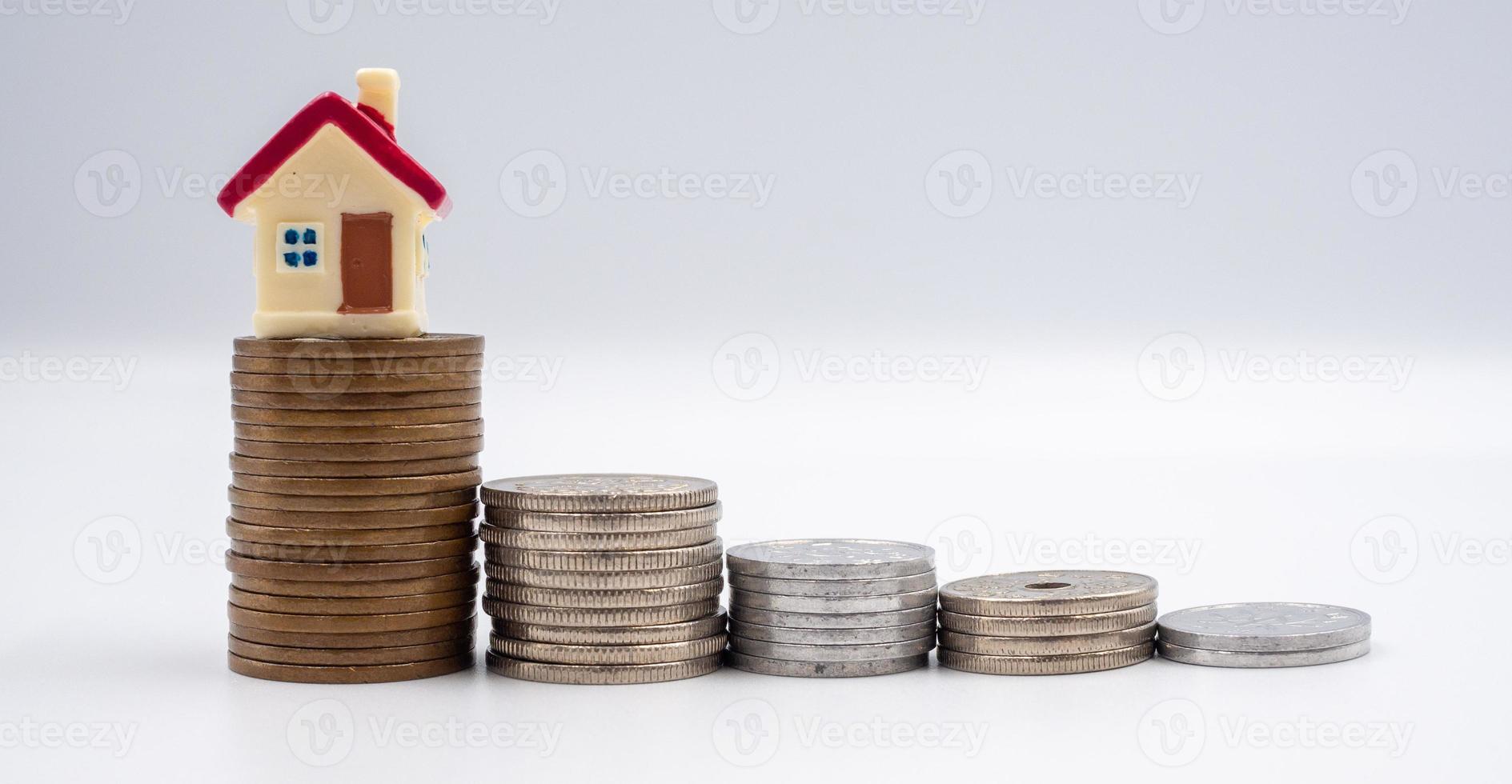 House model and coin on a white background for finance, saving and banking concepts photo