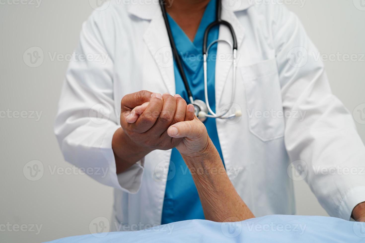 Doctor holding hands Asian elderly woman patient, help and care in hospital. photo