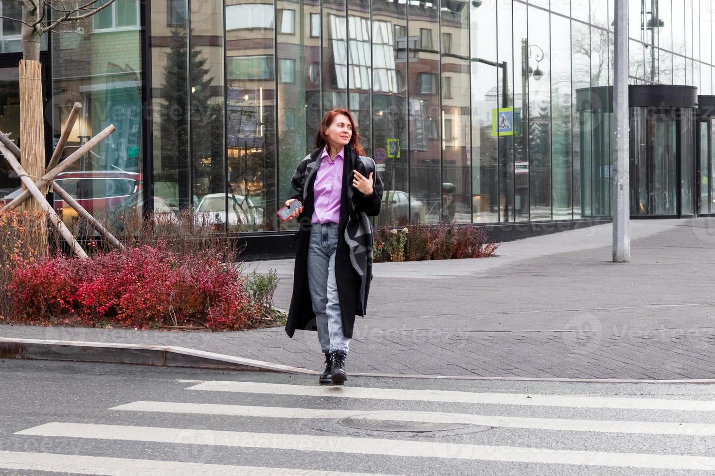 atractivo confidente mujer de negocios es caminando a el céntrico distrito. foto