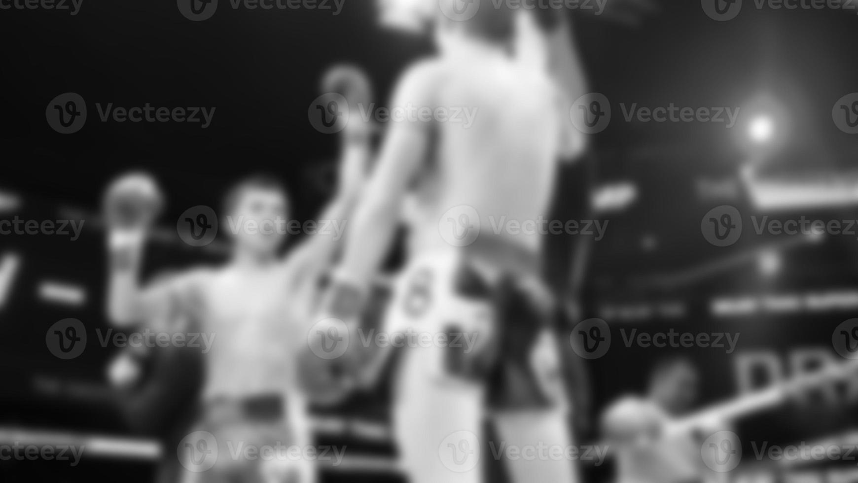 Blurred images black and white photo style of Thai boxing or Muay Thai or Kickboxing which local and foriegn boxer are fighting on the ring at indoor stage as martial art sport. Muay Thai Kick boxing