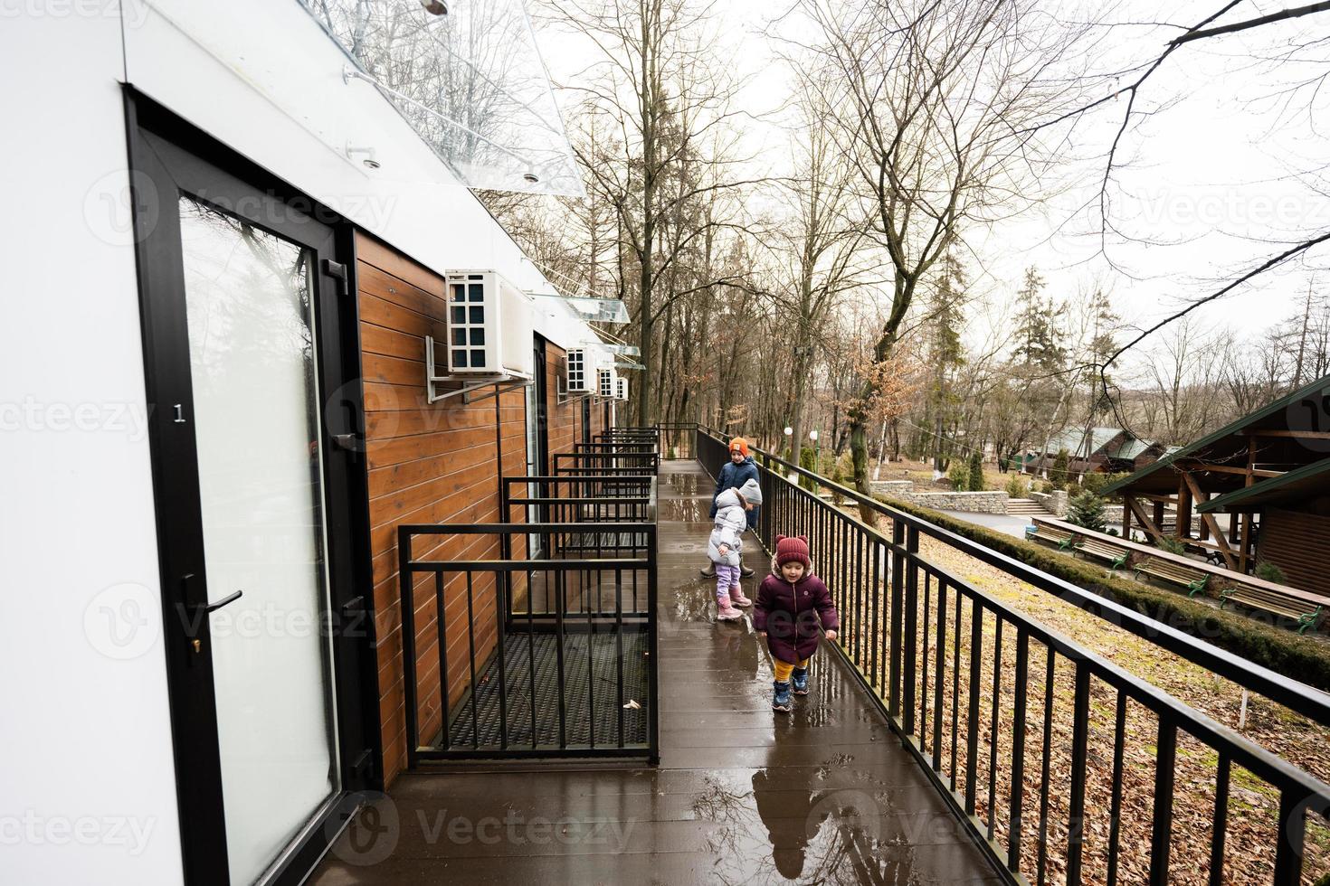 niños caminando en terraza de un piso modular casas en primavera lluvioso bosque. foto