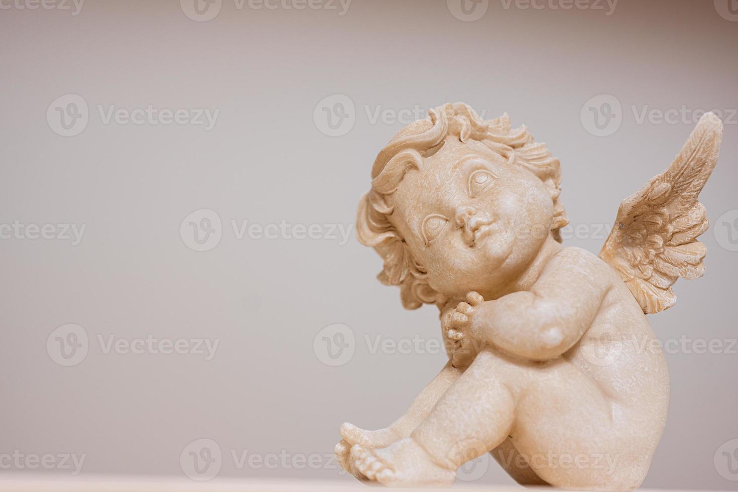 Baby angel with wings antique statue isolated. photo