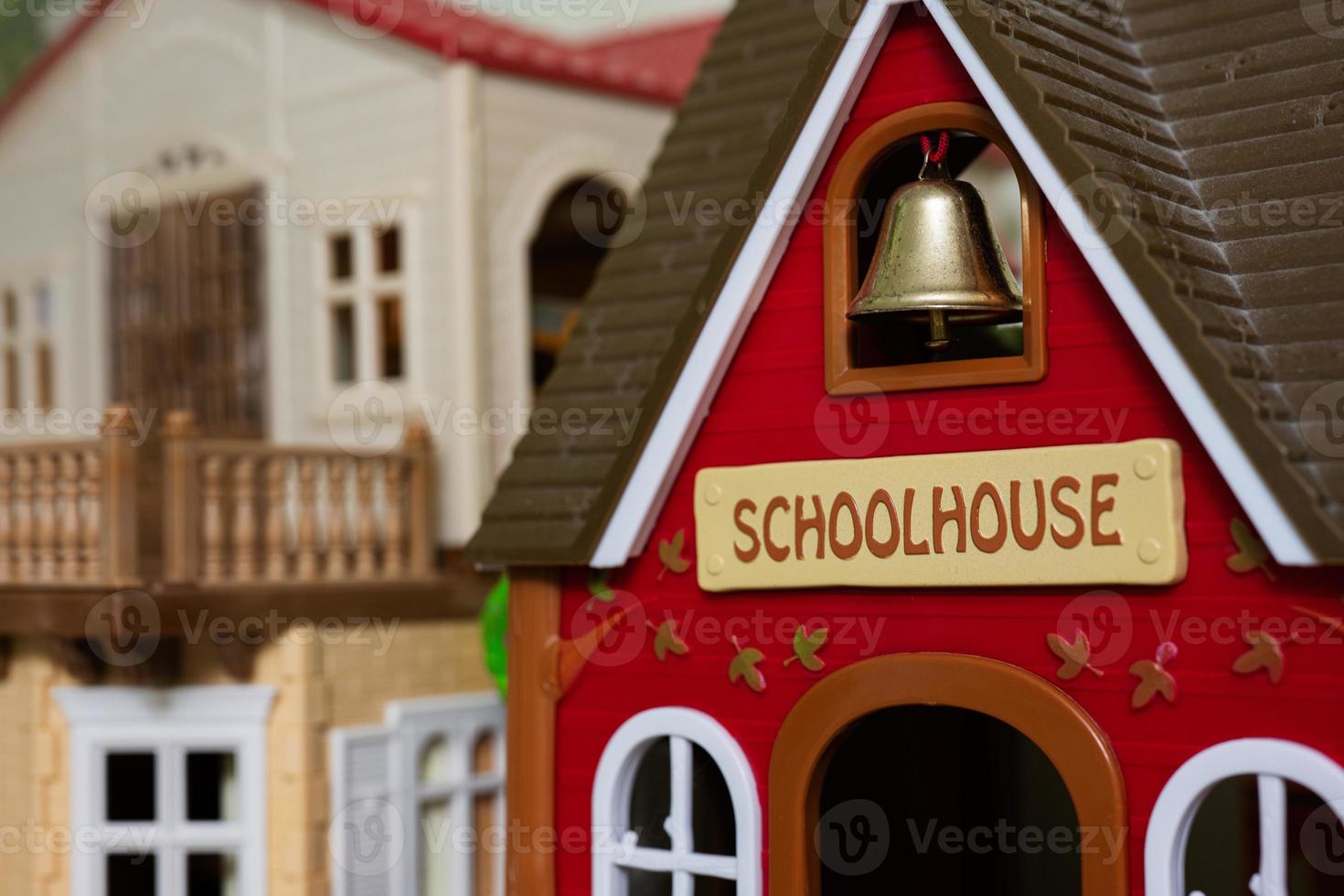 Red school house with bell plastic toy. photo