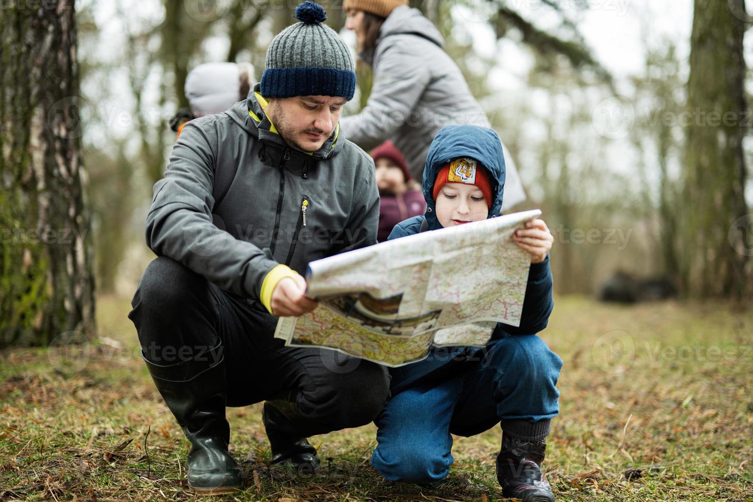 Father with son looking at map in the forest. photo