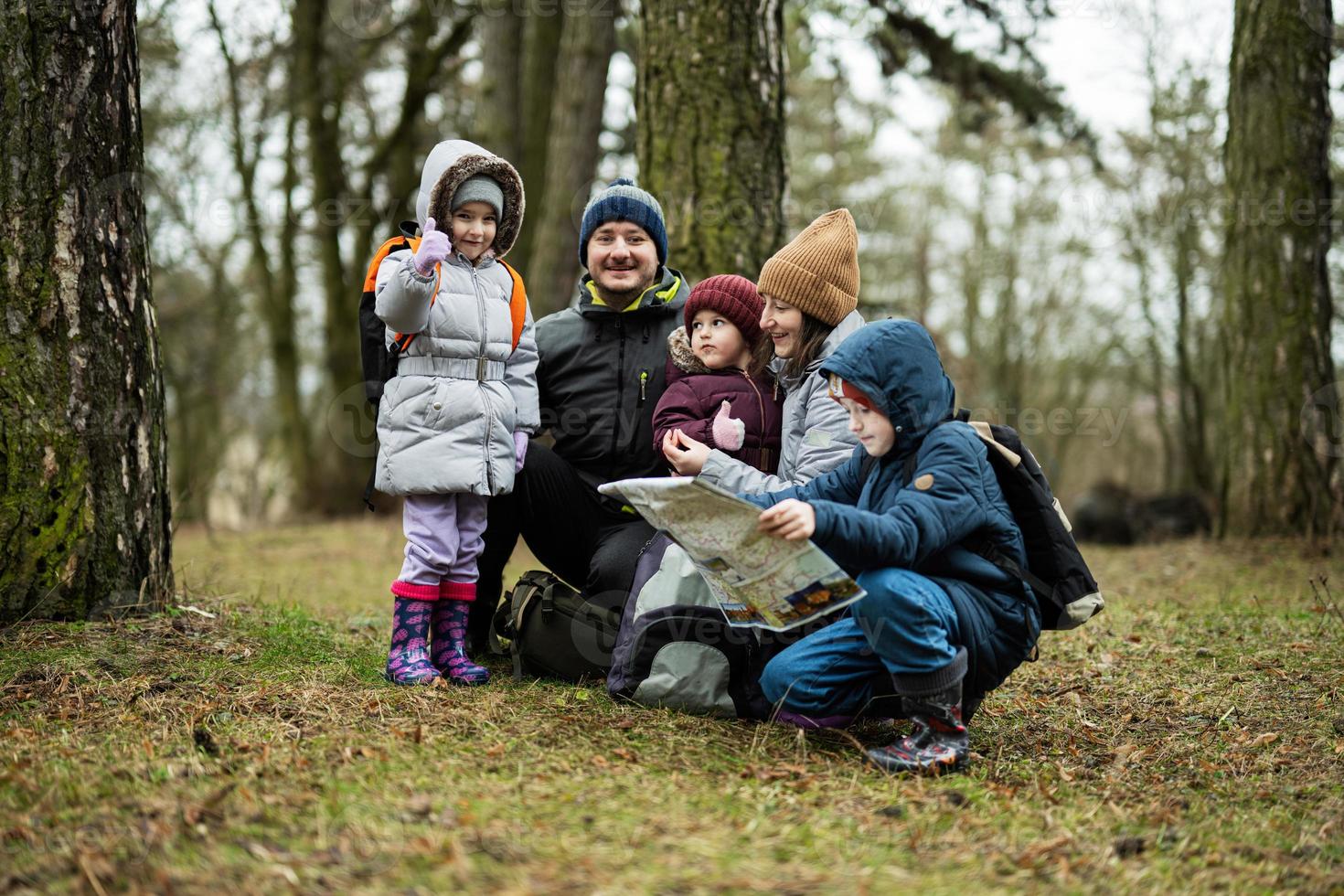 Family and kids with map in the forest. photo